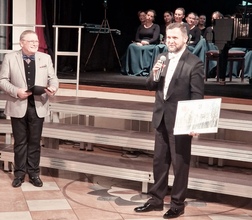 Dyrygent Ireneusz Radzik przekazuje pamiątkową fotografię organizatorom